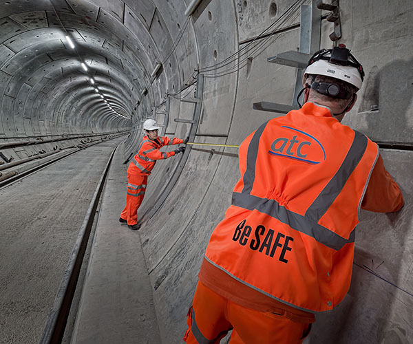 Two workers wearing orange hi-viz in a new rail tunnel