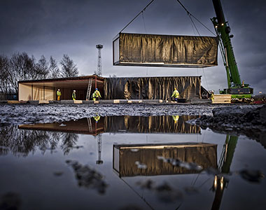 Portable building being craned in